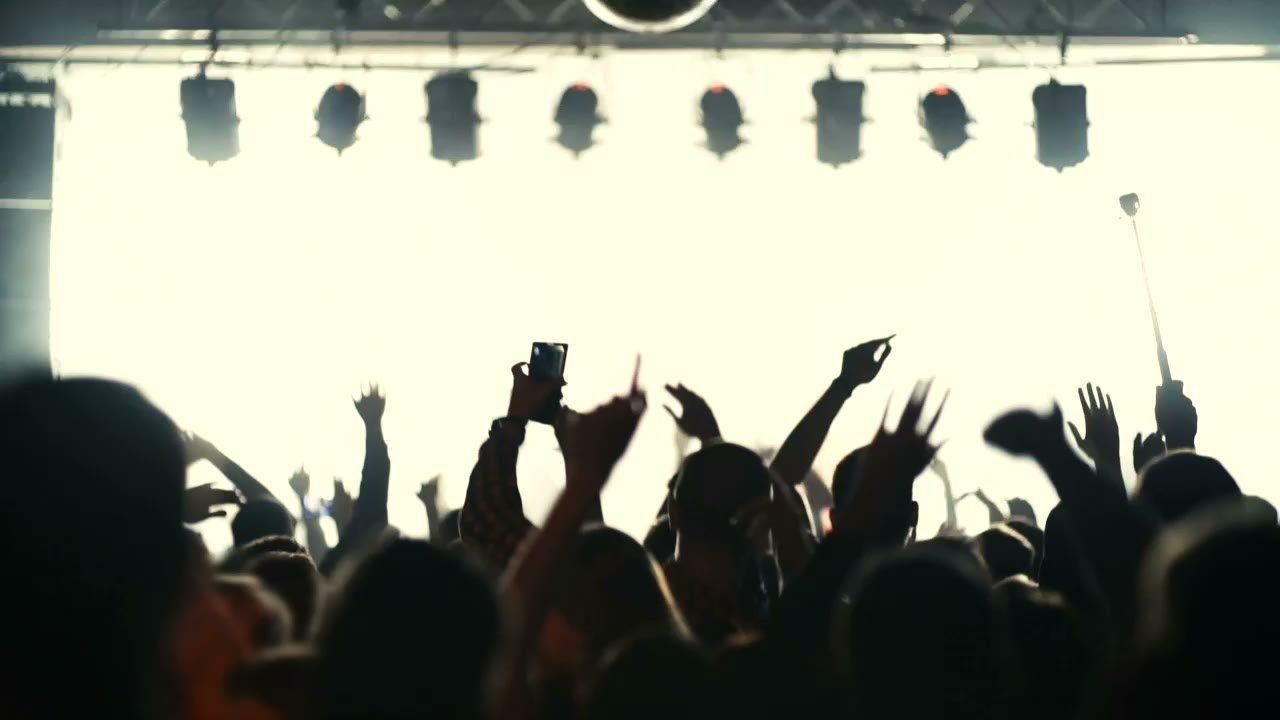 Silhouettes du public devant une scène éclairée (visuel provisoire)